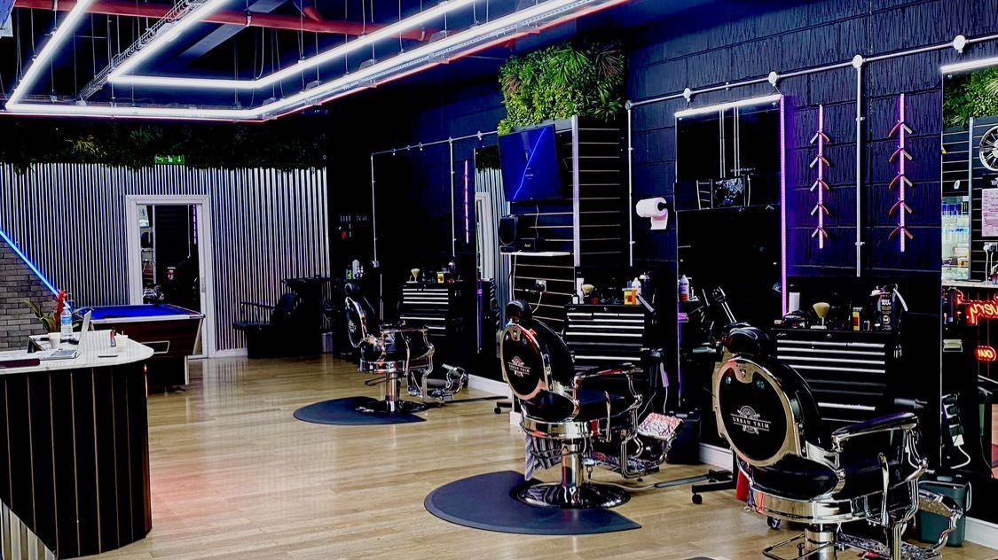 Inside Urban Trim: black barber chairs, illuminated mirrors and geometric ceiling lights